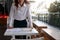 Front view of stressed young Asian business woman standing and smashing on the desk with her hands in office.