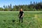 Front view at teenage boy mowing grass with handheld gasoline lawn mower. He wears eye and ear protection headphones. Health and