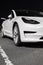 Front view of Tesla electric car. Design, exterior and appearance of white electric car of Tesla Motors automotive company