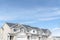 Front view of townhouses against blue sky on a suburban neighborhood landscape