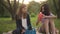 Front view two relaxed Caucasian teenagers sitting on picnic with food and drink in sunshine. Positive teenage girls