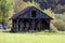 Front view of vintage rustic old dilapidated wooden barn made from wooden boards with open area filled with hay bales for storage