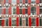 Front view of vintage windows with red wooden shutters of traditional house