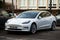 front view of white  testa car parked in the street, tesla is the famous american brand of electric cars