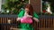 Front view of worried anxious young woman sitting at table in outdoor cafe terrace nervously looking in bag for keys