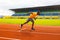 Front view of young afro american male sprinter in yellow sportswear running on the sport track. Concentrated tired