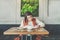 Front view.Young businesswoman is sitting in coffee shop at table,signing documents.Student is studying doing homework.