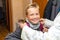 Front view young schoolboy smiles preparing before going to school with mom