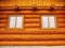 Front wall detail with windows built in wooden beams cabin wall. Painted wood with fungicide light red paint.