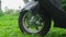 Front Wheel Of Scooter outdoor on green grass.