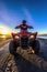 Front wide angle view of man driving ATV in the sand of the beach
