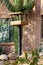 Front yard bird feeder with metal pole and wooden box exterior with outdoor saguaro cactus and brick wall house exterior