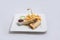 Frontal Hero shot of a beef wrap sandwich with samurai & alger sauce and fries on the side, on a minimal white background