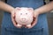 Frontal view of a piggybank held in hands