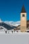 Frost lake Resia with snow and the old steeple in a sunny day, Curon Venosta, Italy