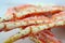 frosted Alaska king crab legs closeup photo on white table background