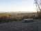 Frosted bench overlooking Small town surrounded by countryside with mountainous background, British Village quaint