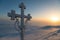 Frosted cross and sunrise scene in mountains