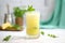 frosted glass of pineapple juice with a sprig of mint on top