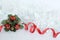 frosted white wreath with red ribbon and green leaves, red gifts on white background for party decoration