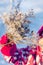 Frosty branch in the hand of a child in bright winter clothes on a blue background close-up. Winter bouquet.