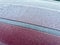 Frosty Layers: Textured Ice Crystals Covering Maroon Car Roof in Chilly Morning Light