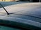 Frosty roof of a green passenger car with heavy icing. police may fine for poorly cleaned car. there must be no snow or ice in the