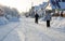 Frosty rural road landscape. Winter snow-covered rural road. People are coming from a ski trip, faces are not visible