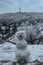 Frosty snowman and Petrin Hill with lookout tower in background selective focus.Prague winter panorama,Czech Republic. Snowy