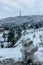 Frosty snowman and Petrin Hill with lookout tower in background selective focus.Prague winter panorama,Czech Republic. Snowy