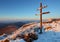 A frosty sunset in mountains with cross