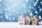 Frosty winter cute houses on snowfall background with copyspace. Festive blue background with Christmas lights, blurred background
