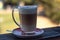 Frothed cappuccino with spoon on a railing