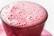 Frothed fruit raspberry and milk mixed beverage with bubbles in glass
