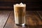 frothy iced chai latte on a rustic wooden table
