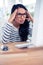 Frowning Asian woman looking at computer monitor with hands on head