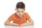 Frowning serious school-age boy in a bright orange polo t-shirt sits at a table. Close-up. Isolirvoan on a white background