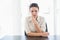 Frowning stylish brunette businesswoman looking at camera and holding her head