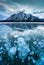 Frozen Abraham Lake with rocky mountains and natural bubbles frost in the morning on winter at Banff national park