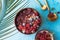 Frozen acai smoothie in coconut shell with raspberries, banana, blueberries,  fruit and granola on concrete background. Breakfast