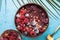 Frozen acai smoothie in coconut shell with raspberries, banana, blueberries,  fruit and granola on concrete background. Breakfast