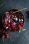 Frozen acai smoothie in coconut shell with raspberries, banana, blueberries,  fruit and granola on concrete background. Breakfast