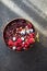 Frozen acai smoothie in coconut shell with raspberries, banana, blueberries,  fruit and granola on concrete background. Breakfast