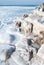 Frozen Baltic sea and concrete tetrapods in sunny winter day. Port entrance and breakwater. Ventspils, Latvia