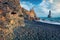 Frozen basalt hexagonal columns on the Atlantic coast. Black sand beach and Reynisdrangar cliffs. Dramatic summer scene of Icelan