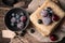 Frozen berries in a Cup and on pancakes on a wooden background.