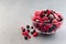Frozen berries in a glass bowl, raspberry, strawberry, cranberry and black currant, horizontal, copy space