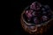 Frozen blueberries in a clay bowl with dark background close up