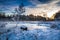 Frozen boat on the lake at sunrise