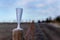 Frozen champagne glass left behind on a fence post after a party on new-year morning. Party leftover garbage in wintery nature.